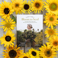 The cover of Floret Farm's Bloom to Seed book surrounded by sunflower blooms.