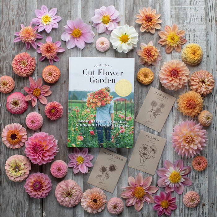 An overhead of Floret Farm’s Cut Flower Garden book and seed packet surrounded by sherbet colored flowers