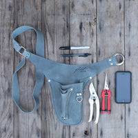 An overhead of Floret’s grey right-handed tool belt, pens, snips, pruners, cell phone
