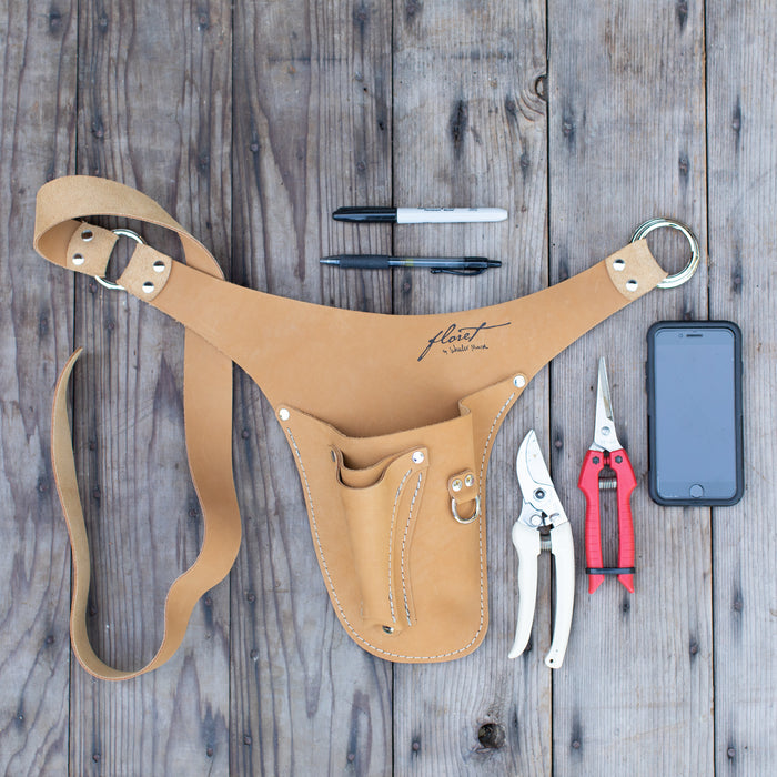 An overhead of Floret’s wheat right-handed tool belt, pens, snips, pruners, cell phone